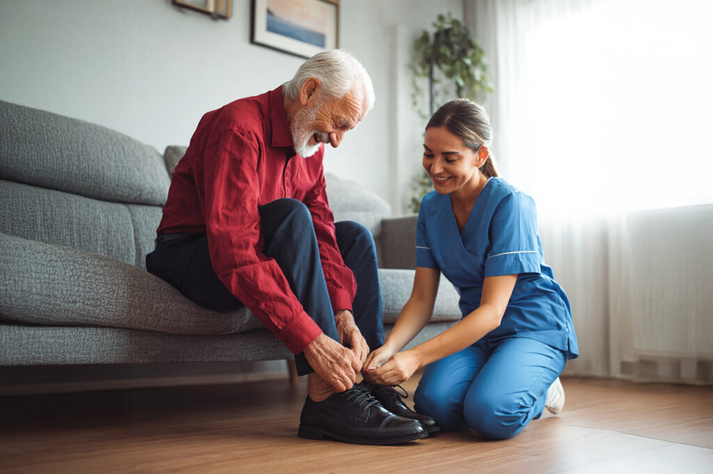 Professional caregiver assisting an elderly man with daily living tasks in the Greater Toronto Area.