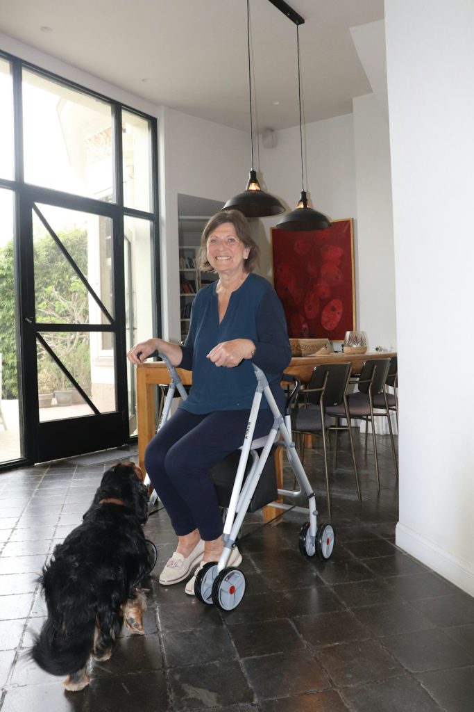 woman-uses-a-walker-with-her-dog-nearby-kmqarfiims