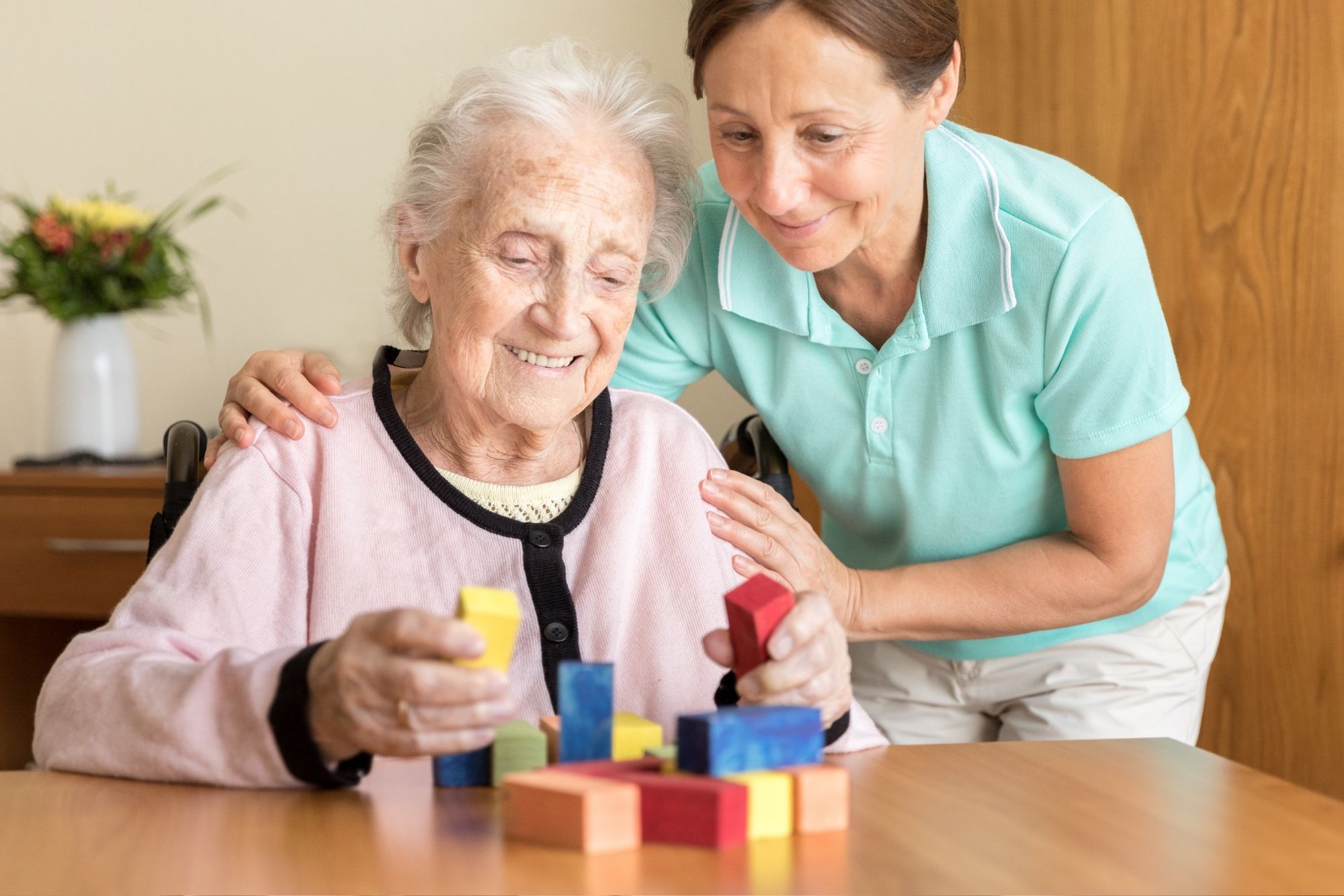 Professional caregiver supporting elderly client with daily activities in Toronto home